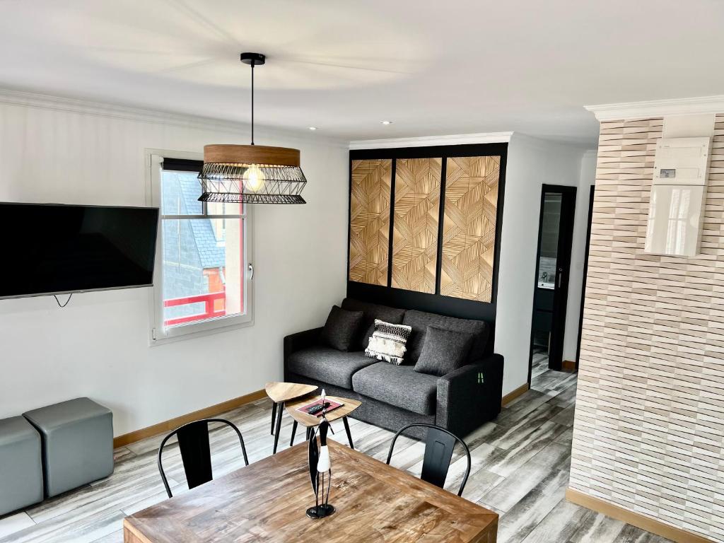 Plage à 50m Appartement Rêves de mer Villa Les Bains de Mers في مير-لي-بان: غرفة معيشة بها أريكة وطاولة