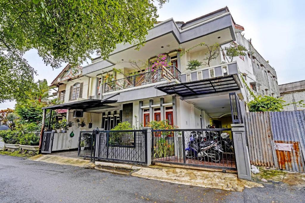 a white house with a balcony on a street at SPOT ON 91482 Sentosa Home in Bandung
