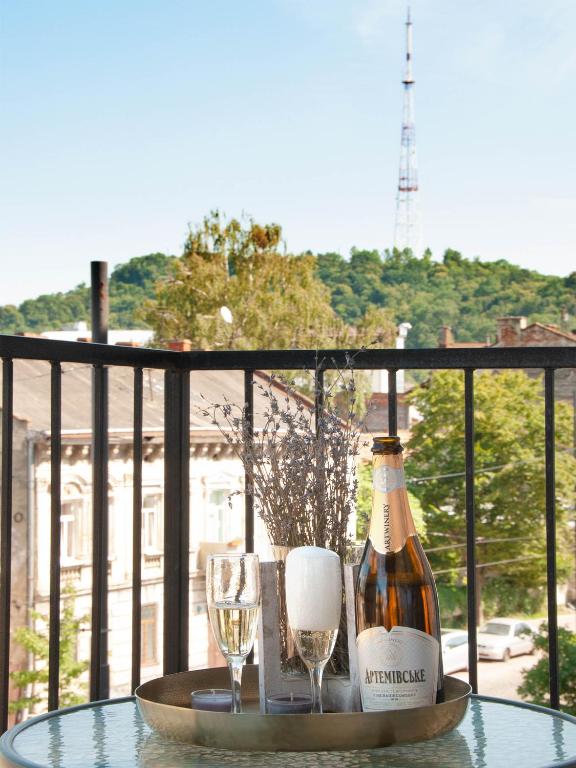 a bottle of wine and two glasses on a table at Sweet Home Avalon in Lviv