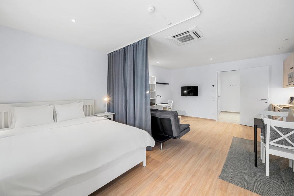 een witte slaapkamer met een bed, een bureau en een bank bij VibeStudio 301 - Central - AC - Licensed - Parking Nearby in Wenen