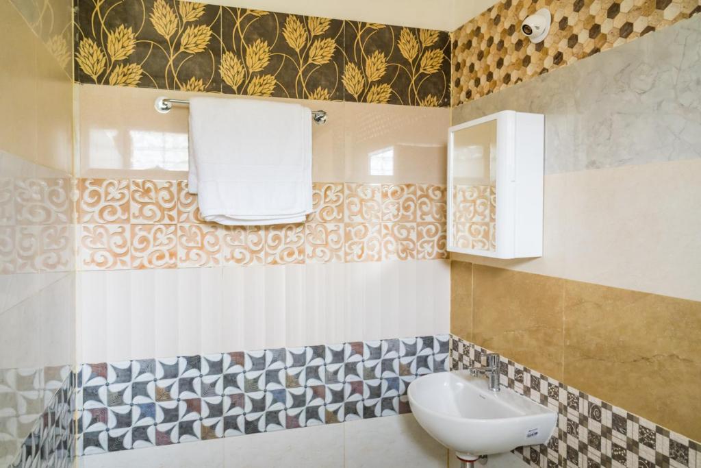 uma casa de banho com um lavatório e um espelho em Tinton Hillstay em Chikmagalur