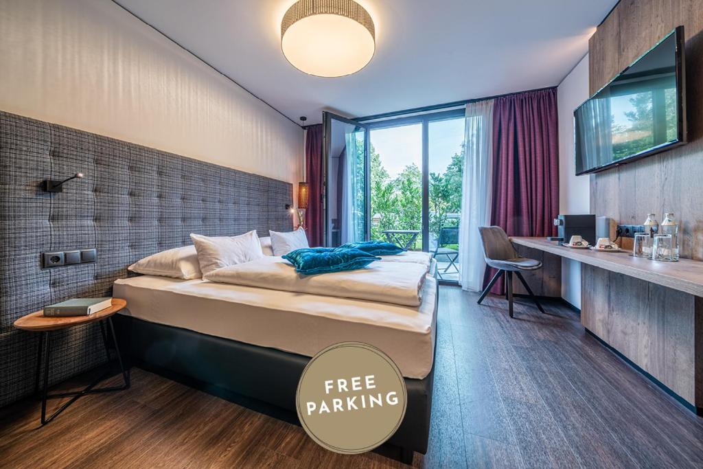 um quarto com uma cama grande e uma janela grande em Rufi's Hotel Innsbruck em Innsbruck