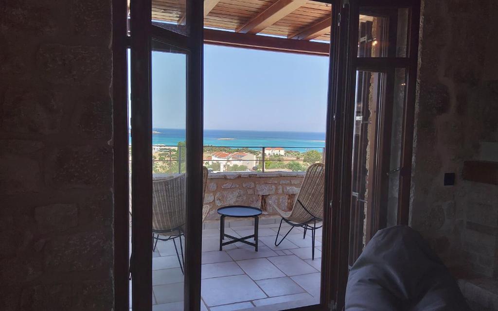 a room with a balcony with a view of the ocean at Harmony Seaview Villas In Elafonisos in Elafonisos