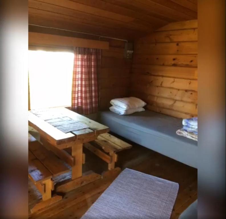 a room with a bed and a table in a cabin at Lätasenonmajat in Enontekiö