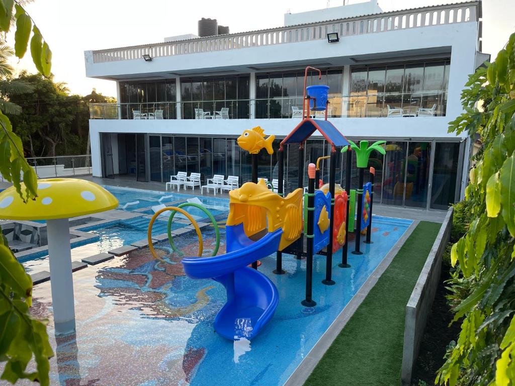einen Pool mit Spielplatz vor einem Gebäude in der Unterkunft Bingo House Watamu, A Modern 5-Bedroom Villa with Pool, A Kids Heaven in Watamu