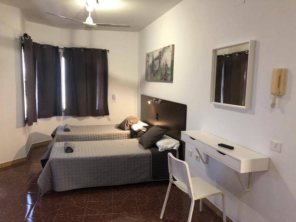una camera con letto, tavolo e scrivania di Tamonante rooms a Gran Tarajal
