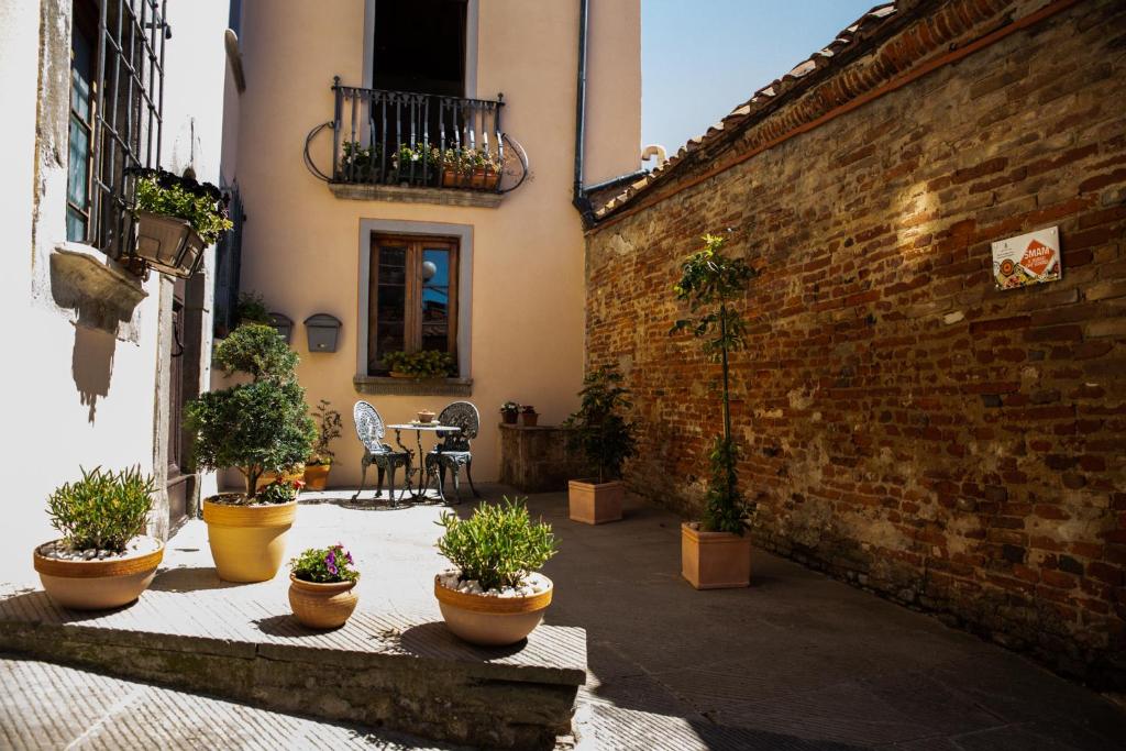 einen Innenhof mit Topfpflanzen und einer Ziegelwand in der Unterkunft Il Libro- Family Holiday in Tuscany in Santa Maria a Monte