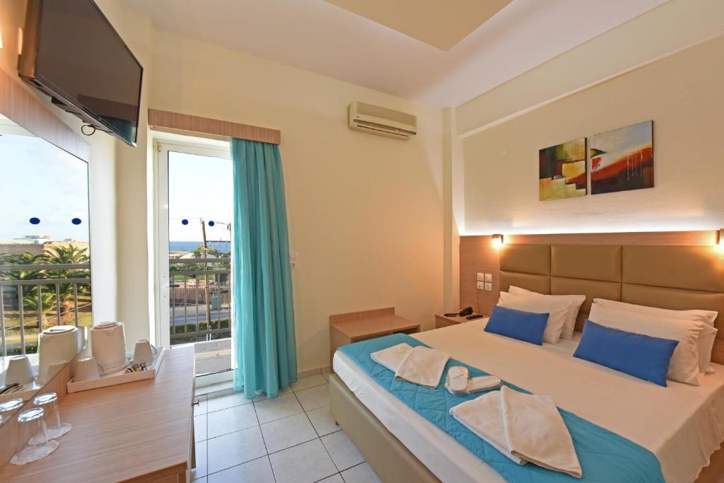 um quarto com uma cama grande e uma janela grande em Sun Boutique Hotel (Adults Only) em Amoudara Herakliou