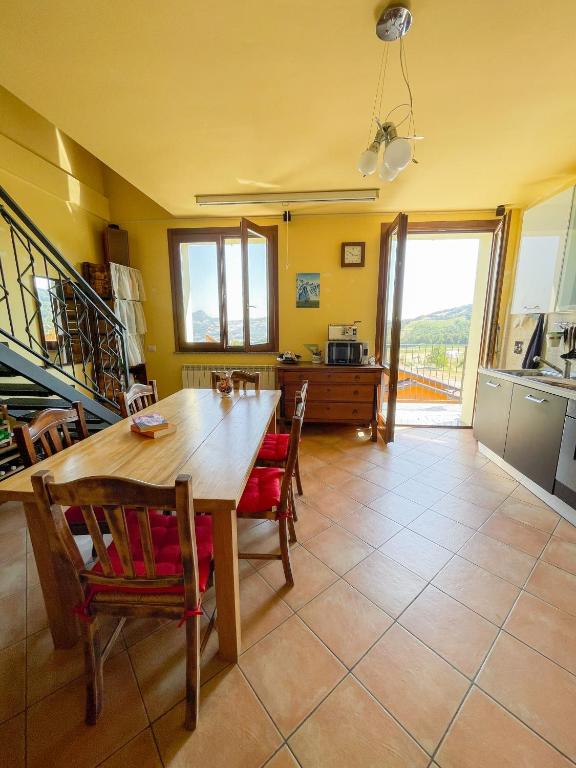 una cucina e una sala da pranzo con tavolo e sedie in legno di Appartamento vista colline a Cavola