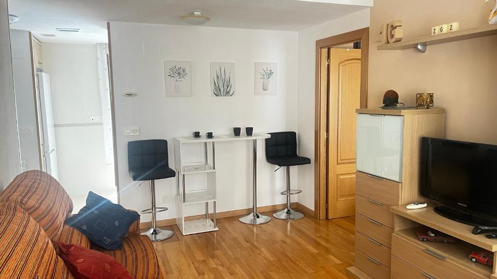 ein Wohnzimmer mit 2 Stühlen und einem TV in der Unterkunft El Primero G Zaragoza - Aljafería in Saragossa