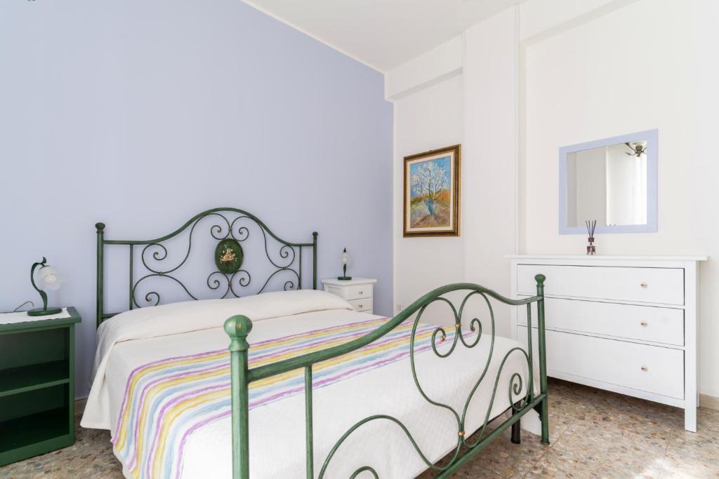 a white bedroom with a bed and a dresser at Casa Sofocle Comodo bivani a Siracusa posto nell'antico quartiere della Borgata in Syracuse