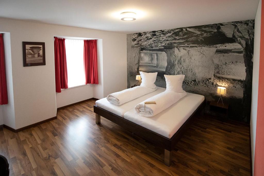 ein Schlafzimmer mit 2 Betten und einem Wandgemälde in der Unterkunft Gasthof Löwen Herznach in Herznach