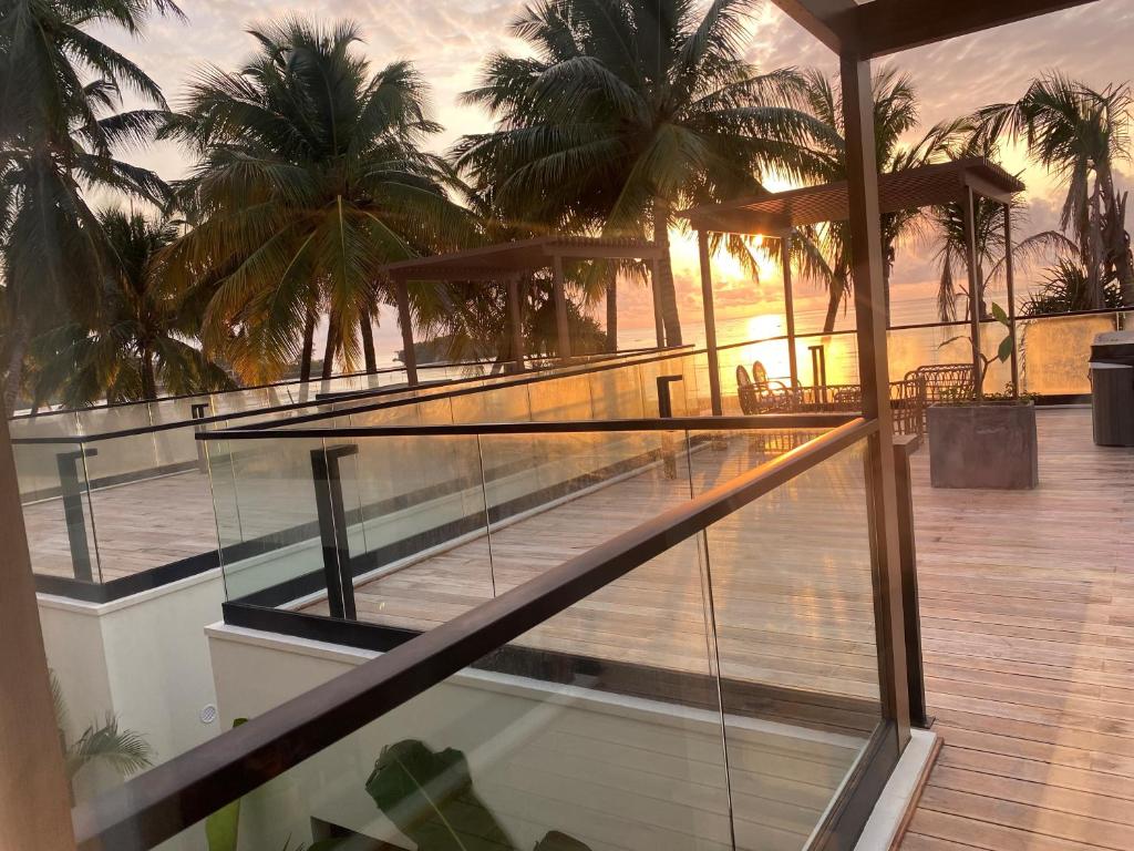a balcony with a view of the ocean and palm trees at TOA Hotel & Spa Zanzibar in Pongwe