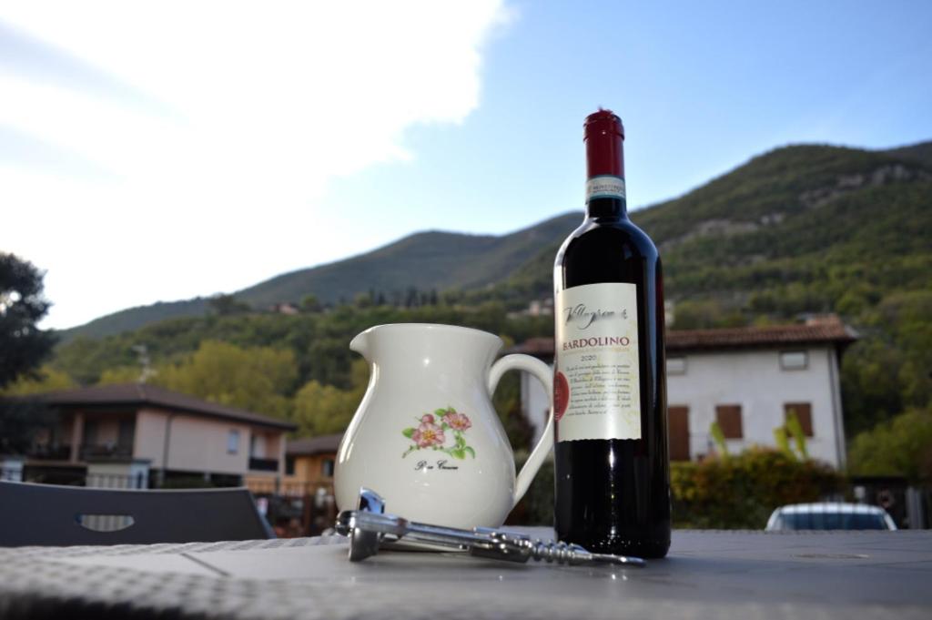 una botella de vino sentada en una mesa junto a un jarrón en Appartamento Vale, en Villanuova sul clisi