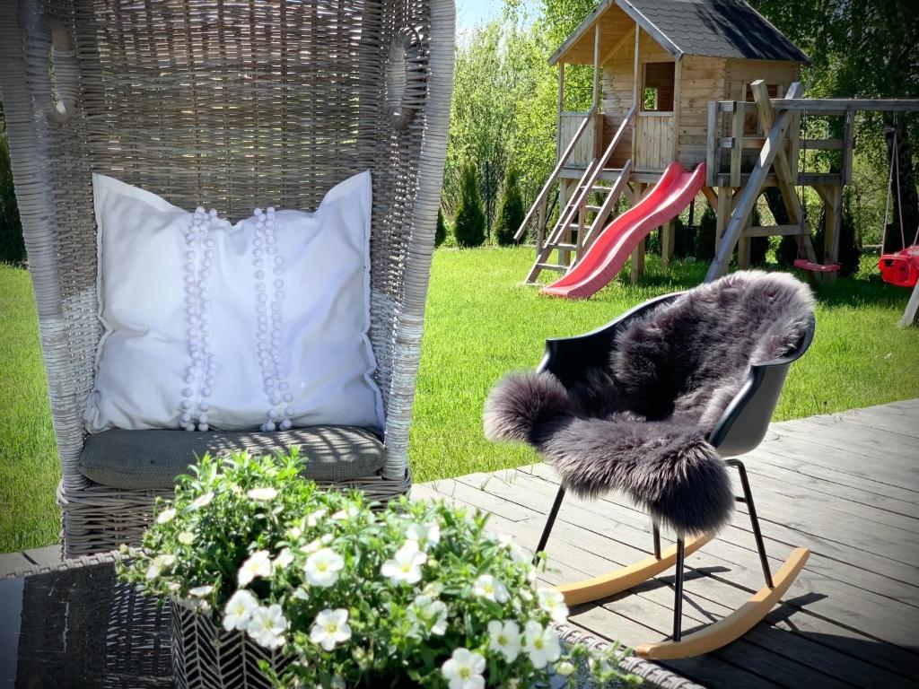 a chair and a pillow on a deck with a playground at AHOY - Haus am Meer in Chłopy