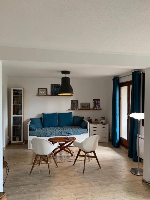 a living room with a couch and a table and chairs at Appartement spacieux et lumineux in Sélestat