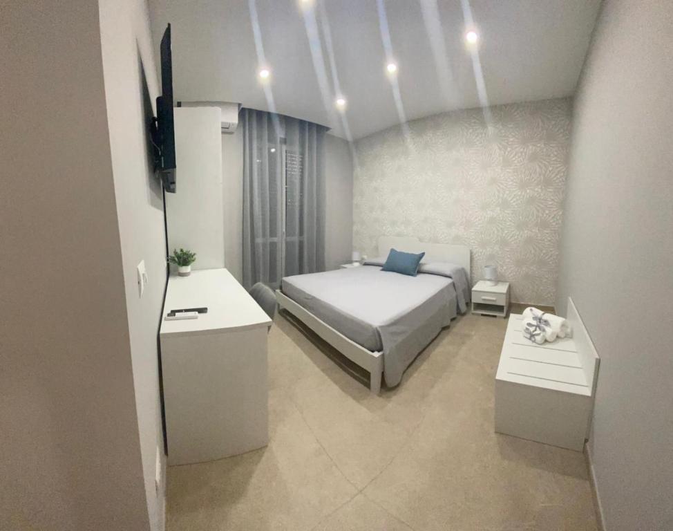 ein Schlafzimmer mit einem Bett, 2 Tischen und einem TV in der Unterkunft Albadorata in Praia a Mare