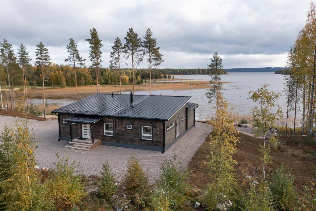 a small cabin on the shore of a lake at Villa Kannas 1 in Juuka