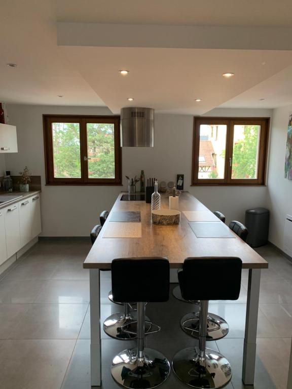 a kitchen with a large island with two bar stools at Appartement spacieux et lumineux in Sélestat