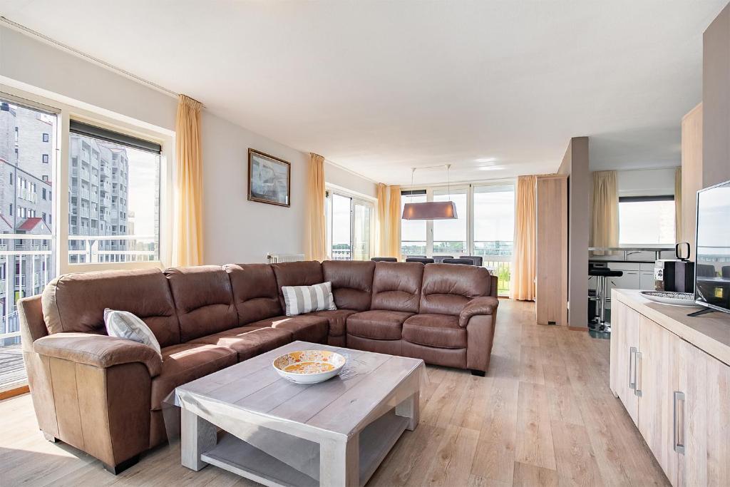 ein Wohnzimmer mit einem Sofa und einem Tisch in der Unterkunft Hello Zeeland - Appartement Port Scaldis 15-042 in Breskens