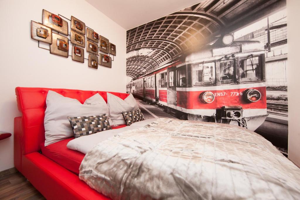 ein Schlafzimmer mit einem roten Bett und einem Wandbild des Zuges in der Unterkunft Deluxe Apartment Vienna in Wien