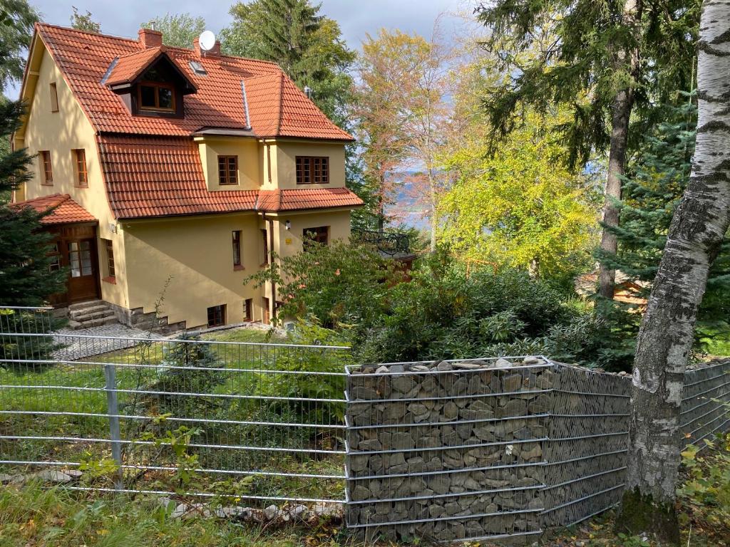 an old house with a red roof and a fence at Willa pod Seidorfem in Sosnówka