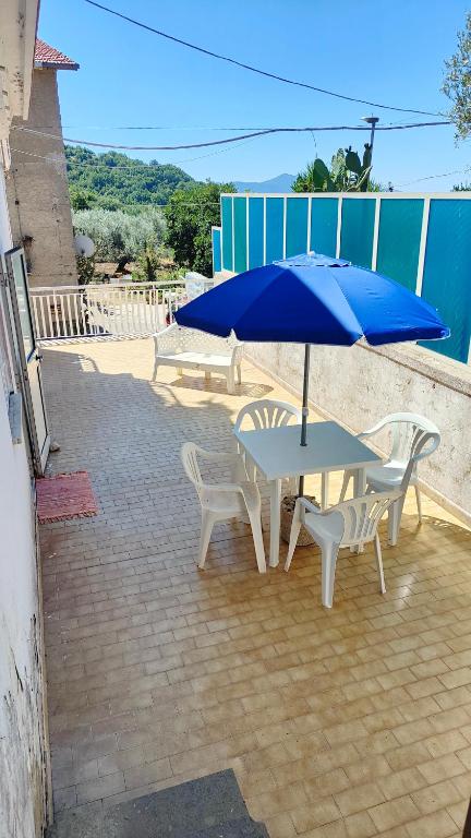 een tafel en stoelen met een blauwe parasol bij Al Piccolo Alloggio in San Carlo