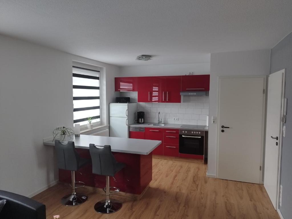 a kitchen with red cabinets and black appliances at Ferienwohnung Bianca in Nordhausen