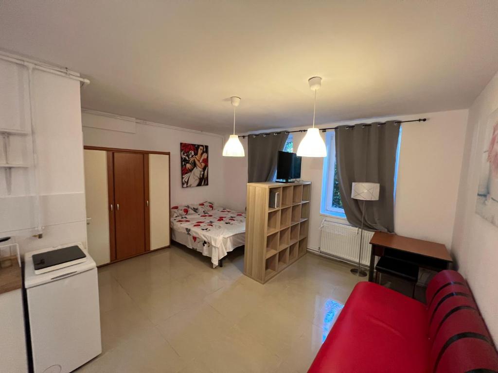 Cette petite chambre comprend un lit et un canapé rouge. dans l'établissement Bastion Apartament 2, à Timişoara