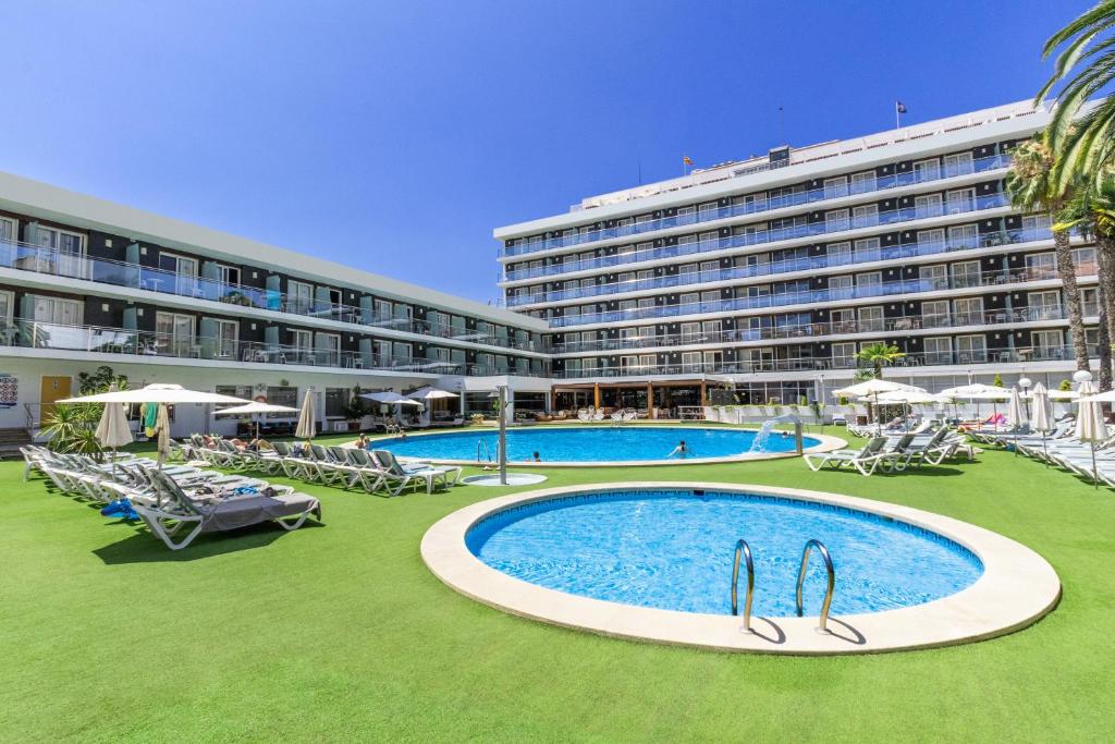 a large hotel with a large swimming pool in front of a building at Hotel Anabel in Lloret de Mar