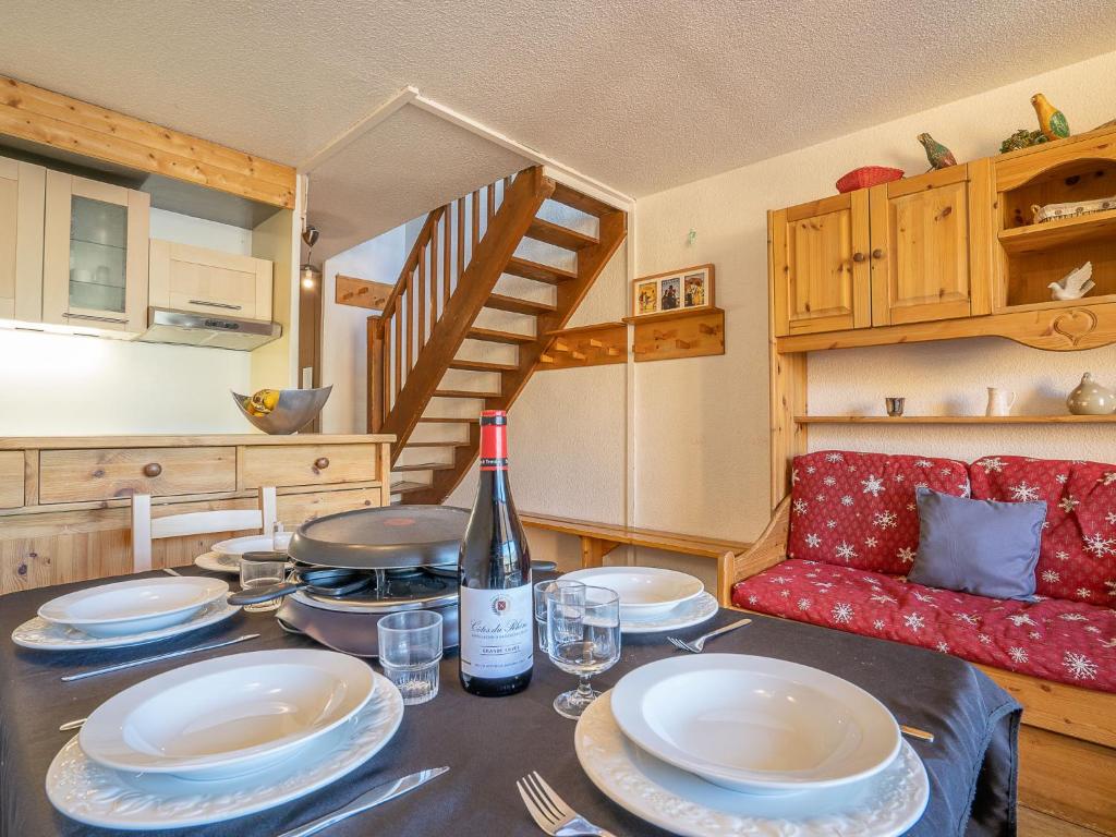 - une table à manger avec des assiettes et une bouteille de vin dans l'établissement Apartment Roche Blanche 183 by Interhome, à Val Thorens