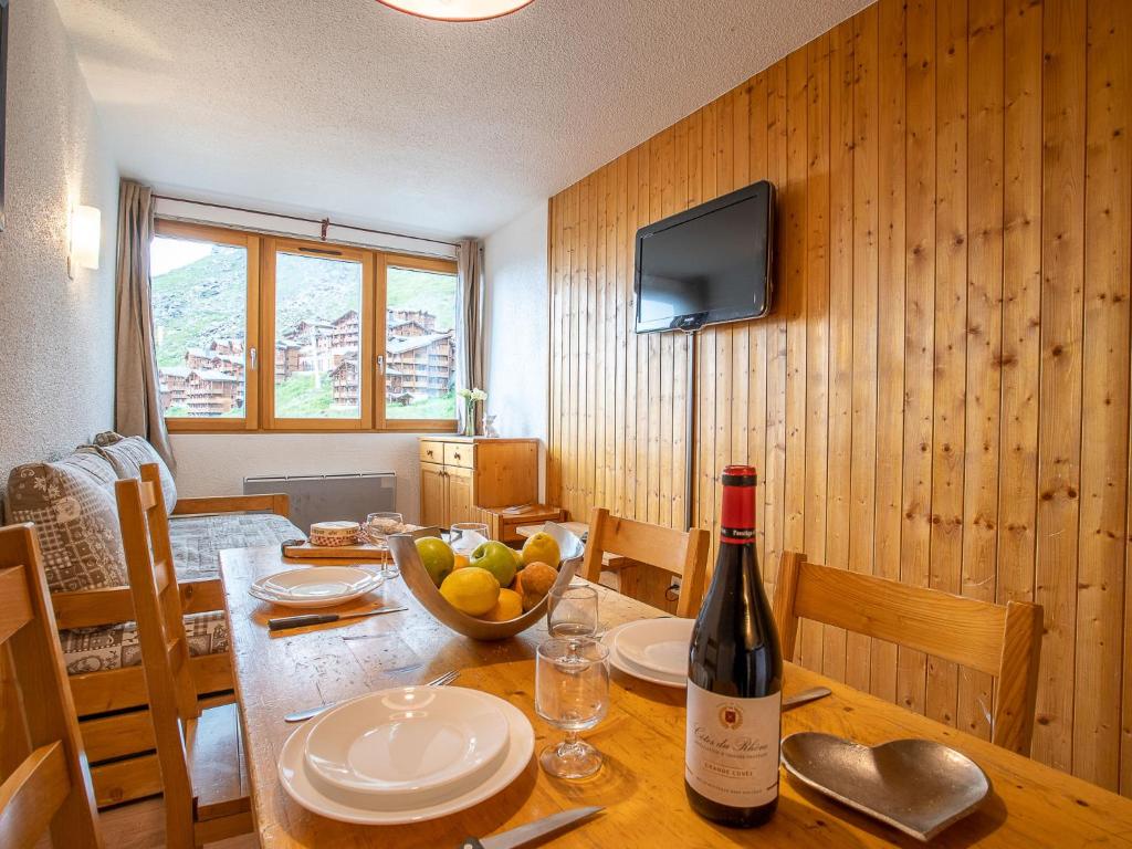 una mesa con una botella de vino y un bol de fruta en Apartment Arcelle 614 by Interhome, en Val Thorens