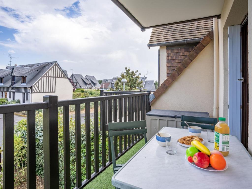 a table on a balcony with a bowl of fruit at Apartment Fleur Marine-5 by Interhome in Cabourg