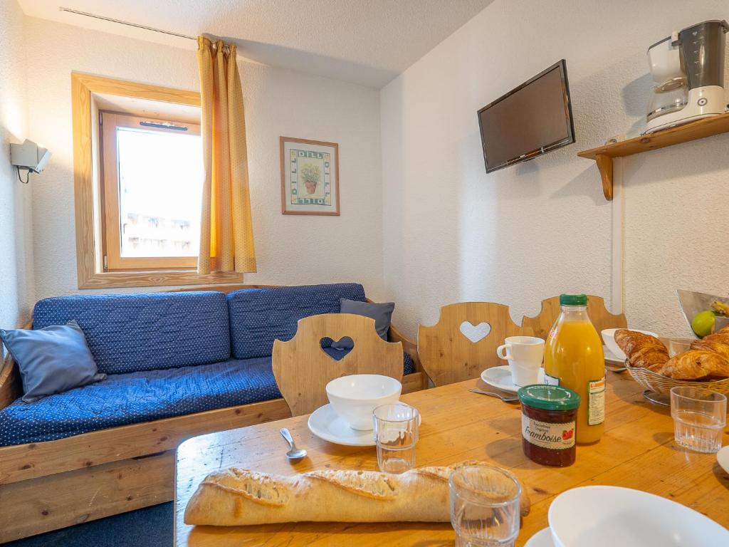 - un salon avec un canapé bleu et une table en bois dans l'établissement Apartment Arcelle 111 by Interhome, à Val Thorens