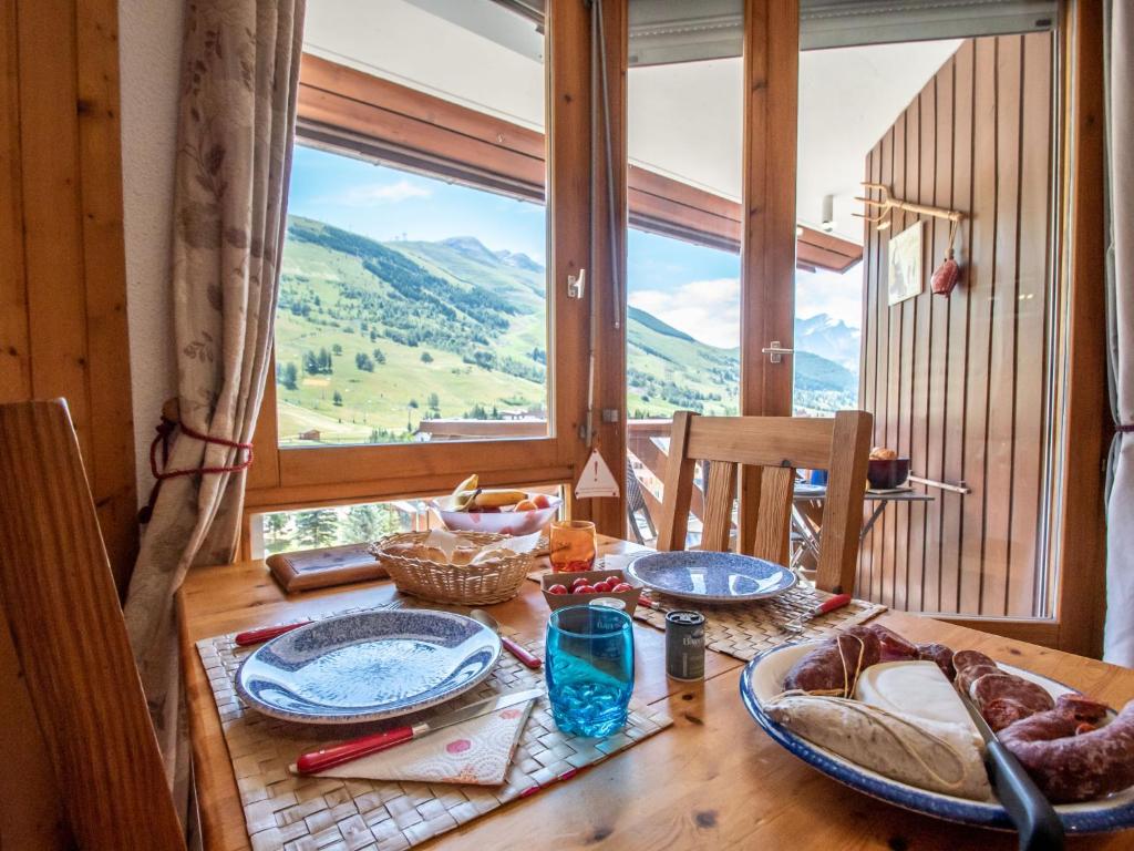 una mesa con platos de comida en ella con una ventana en Apartment La Grande Chaume by Interhome, en Les Deux Alpes