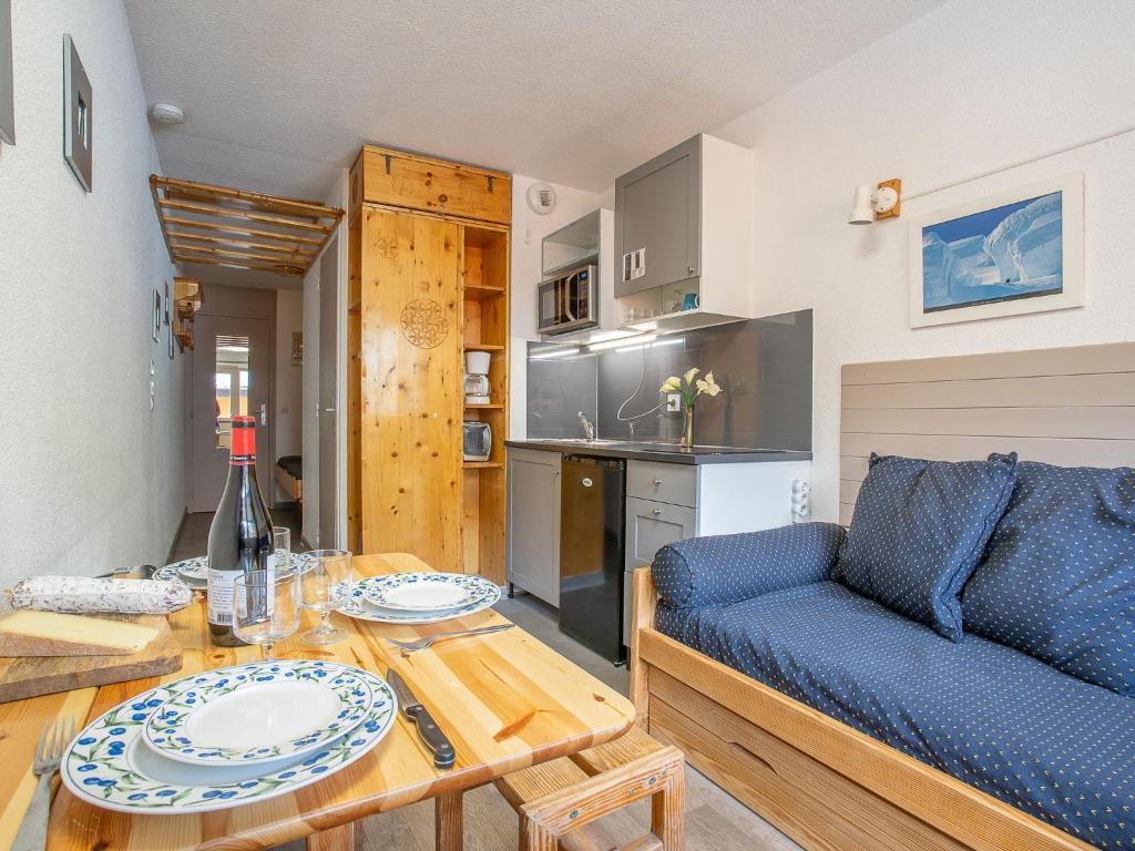 a living room with a table and a blue couch at Apartment Vanoise-9 by Interhome in Val Thorens