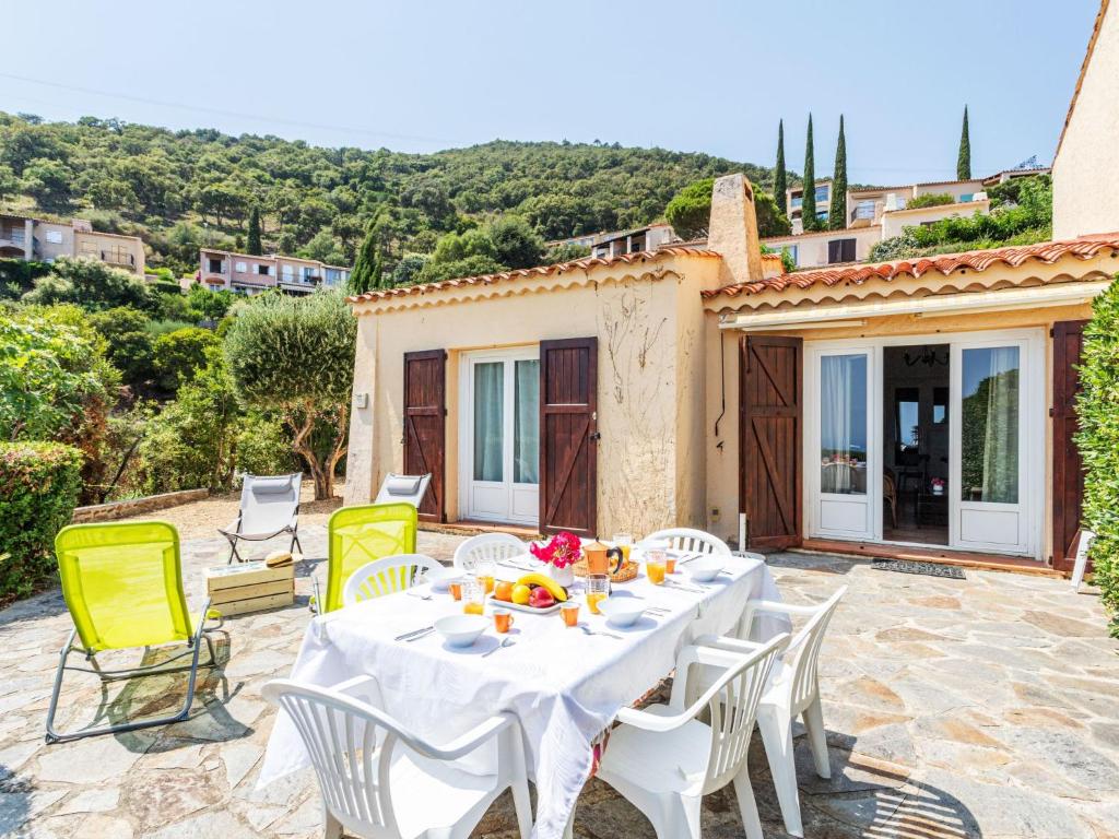 d'une terrasse avec une table et des chaises blanches. dans l'établissement Holiday Home Domaine des Collieres-7 by Interhome, à Cavalaire-sur-Mer