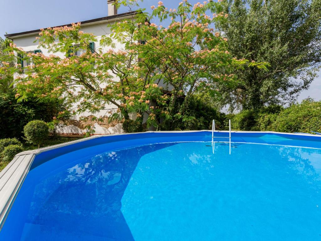 a blue swimming pool in front of a house at Holiday Home Fonte del Ceppo 1 by Interhome in Tortoreto Lido