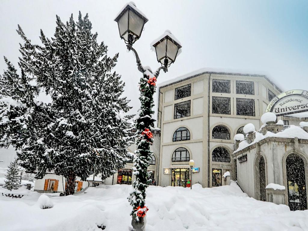 a street light covered in snow next to a christmas tree at Apartment Universo-1 by Interhome in Pré-Saint-Didier