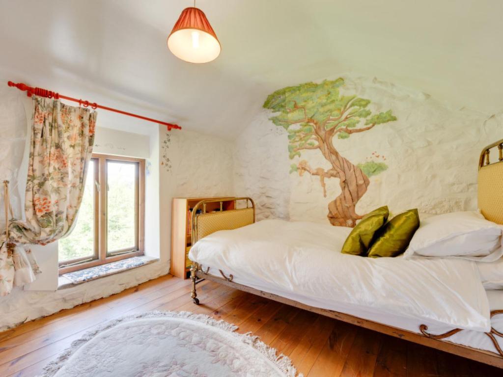 BrynammanにあるHoliday Home Cwmllynfell by Interhomeのベッドルーム1室(木の壁画のあるベッド1台付)