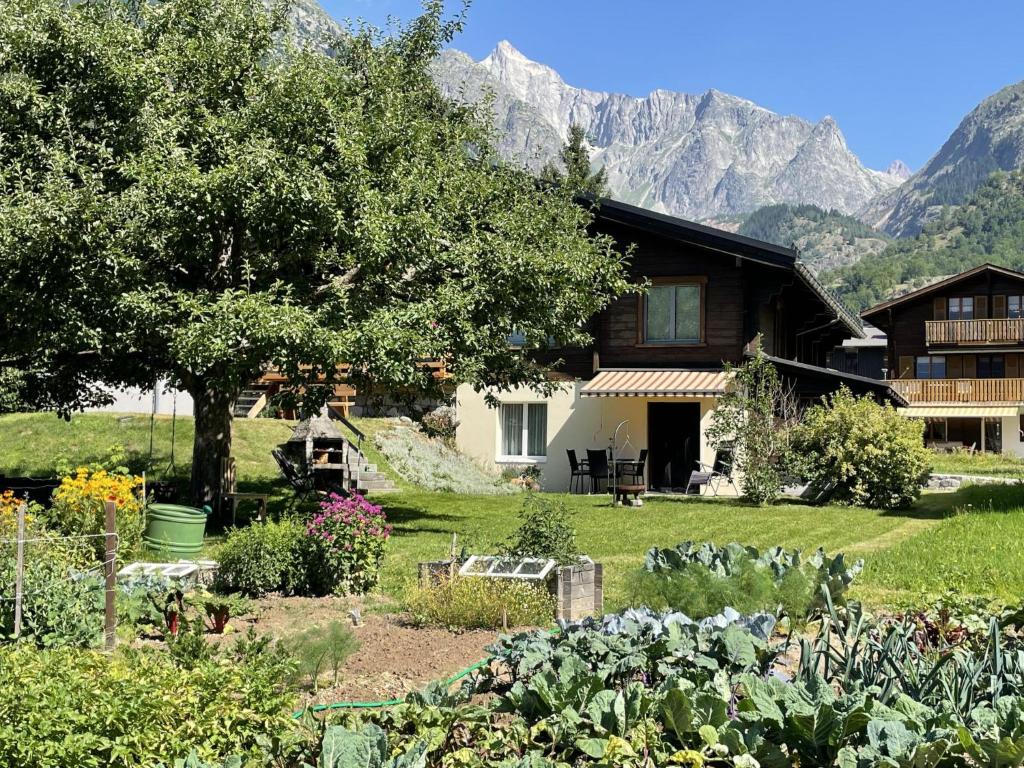 a garden in front of a house with mountains in the background at Apartment Sweda by Interhome in Fieschertal