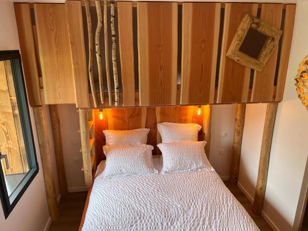 a bedroom with a bed with two white pillows at LE DOMAINE DES CYGNES in Lamballe