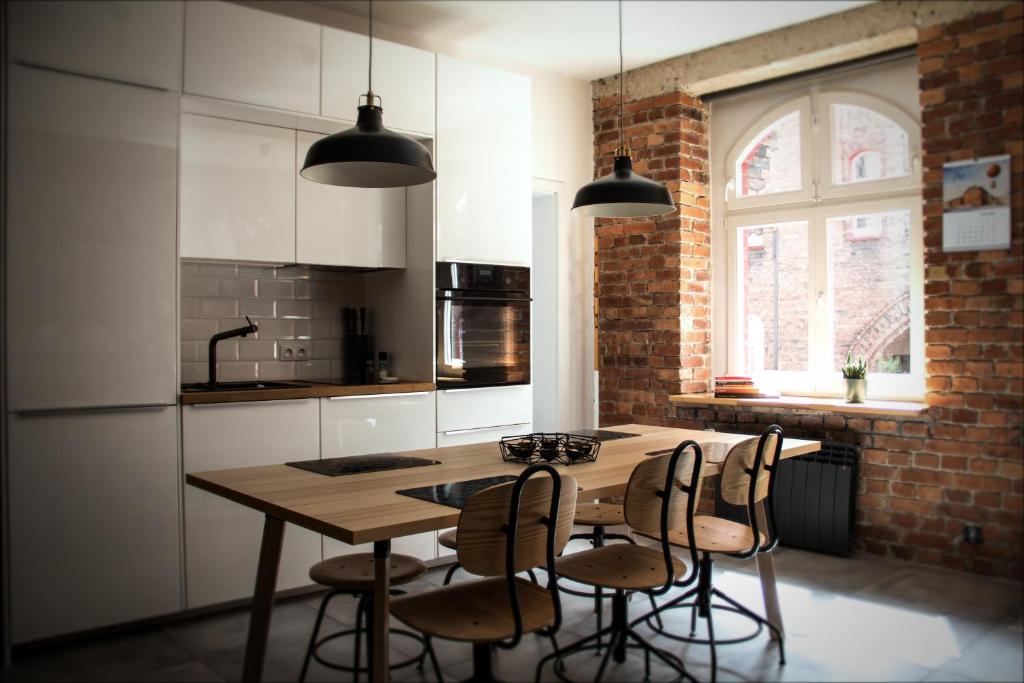 kuchnia z drewnianym stołem i 4 krzesłami w obiekcie Dom na Nikiszu w mieście Katowice