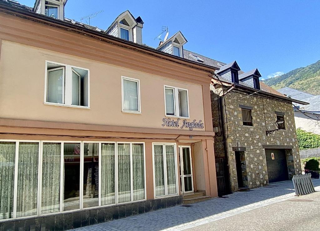 a building with a sign on the side of it at Hotel Anglada in Vielha