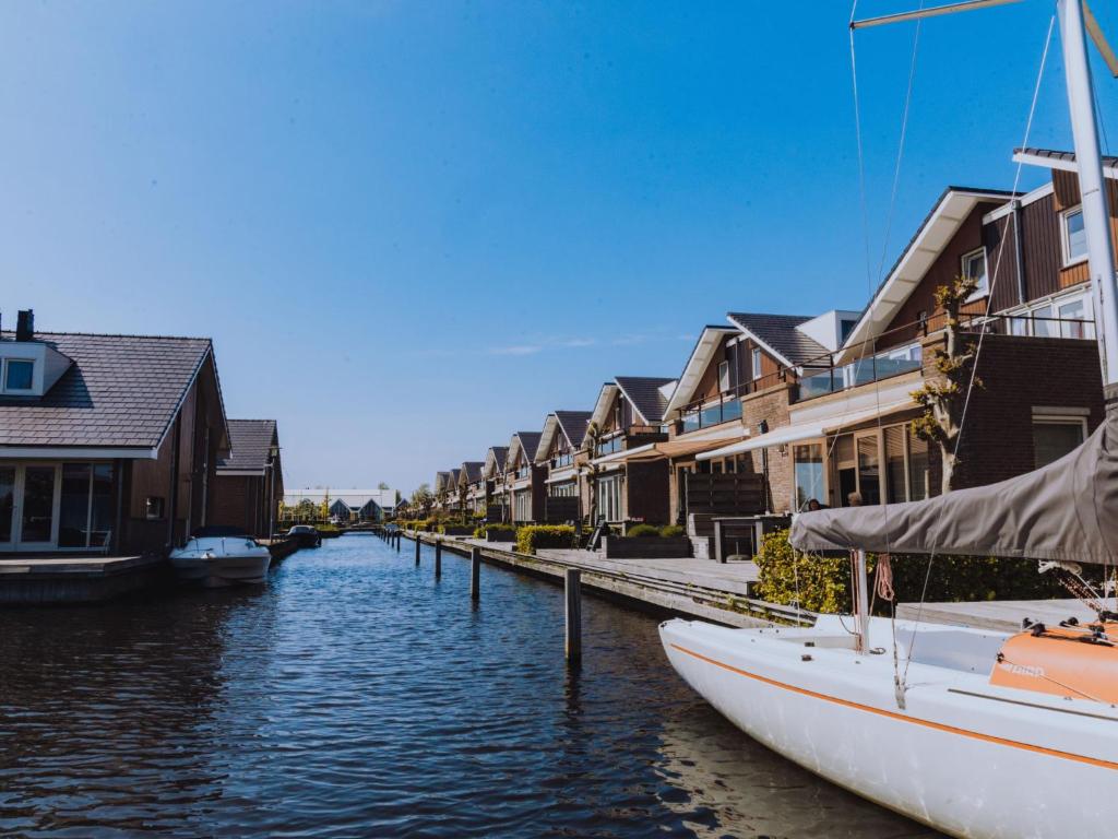 uma fila de casas ao lado de um canal com um barco em Holiday Home De Meerparel-1 by Interhome em Uitgeest