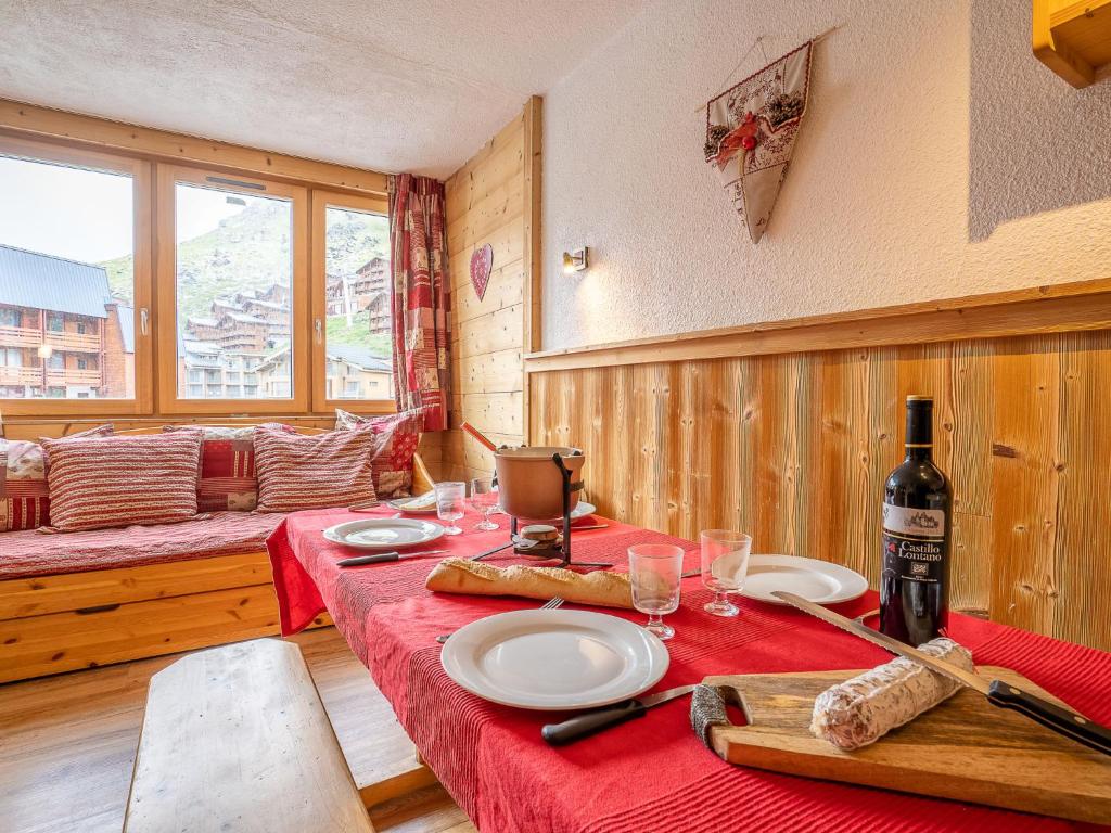 una sala da pranzo con tavolo e bottiglia di vino di Apartment Arcelle-22 by Interhome a Val Thorens