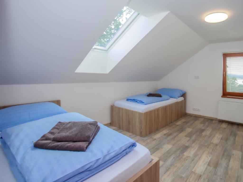 sypialnia na poddaszu z dwoma łóżkami i oknem w obiekcie Holiday Home Dehtáře by Interhome w mieście Hluboká nad Vltavou