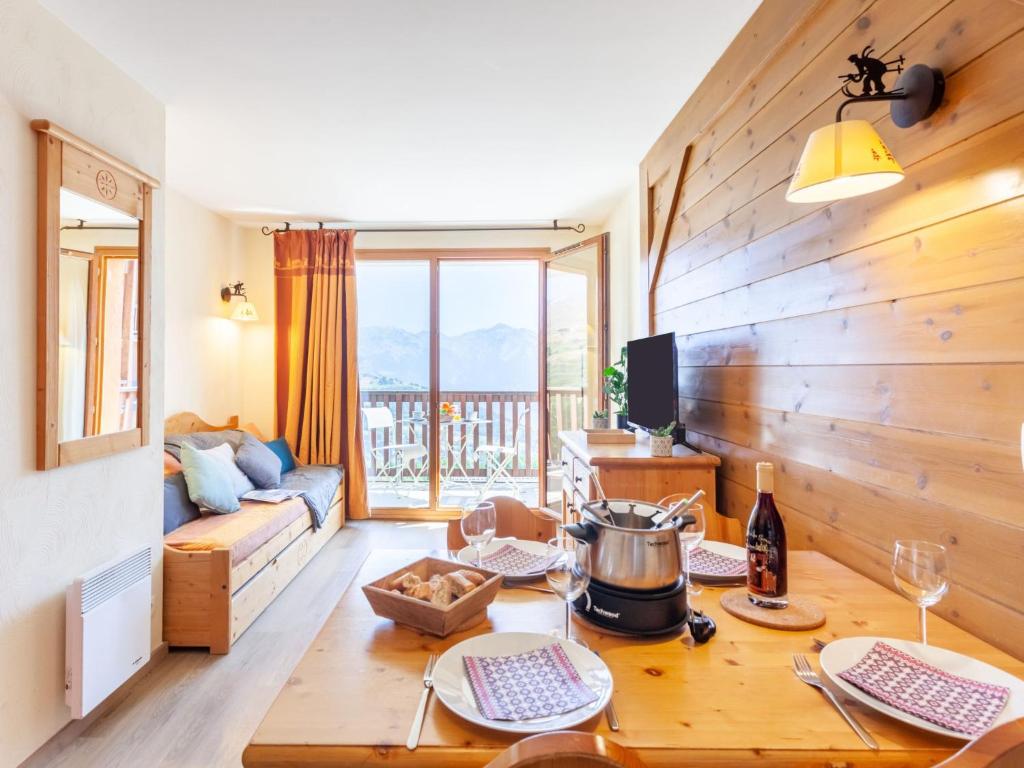 ein Wohnzimmer mit einem Tisch und einem Sofa in der Unterkunft Apartment Les Alpages du Corbier-7 by Interhome in Le Corbier