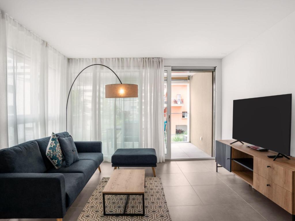 a living room with a couch and a flat screen tv at Apartment LocTowers A2-8-1 by Interhome in Locarno