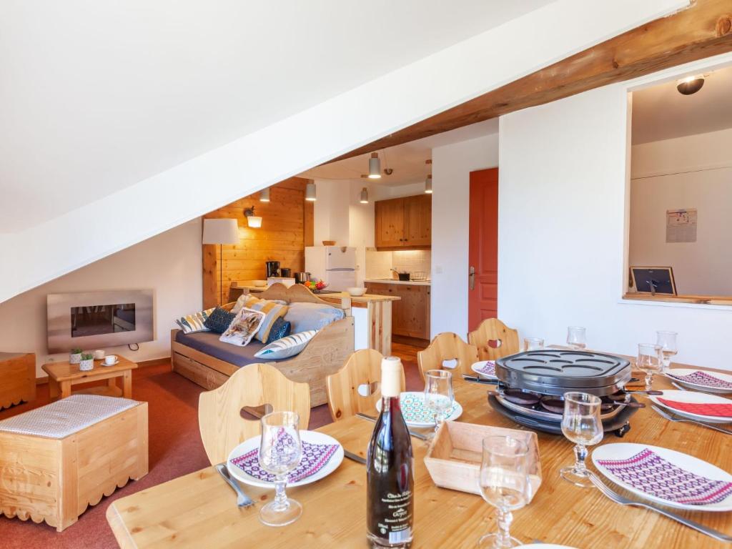 ein Esszimmer und ein Wohnzimmer mit einem Tisch und Stühlen in der Unterkunft Apartment Les Alpages du Corbier-10 by Interhome in Le Corbier